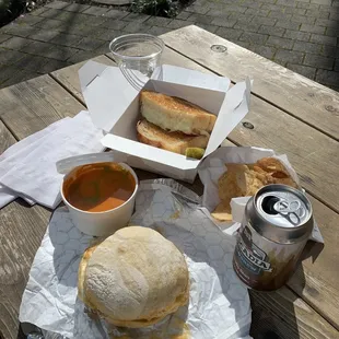 Breakfast sandwich, tomato, soup, grilled cheese, and can of cold brew coffee.