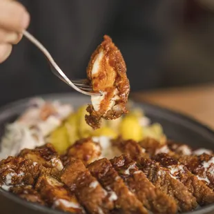 a person holding a fork over a plate of food