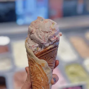 a hand holding an ice cream cone