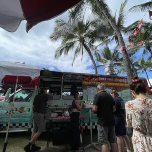 a group of people standing around a food truck