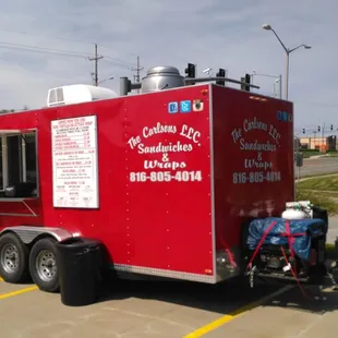 a red food truck parked in a parking lot
