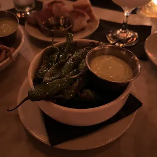 a bowl of green peppers and dipping sauce