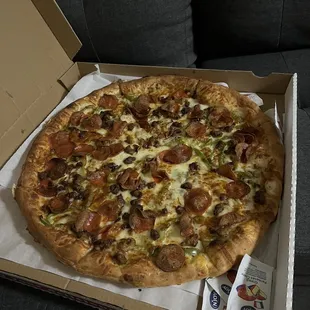 a pizza in a box on a couch