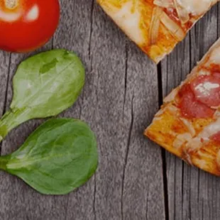 a slice of pizza with spinach, tomatoes, mushrooms, and cheese