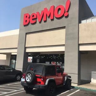 a jeep parked in front of a bevmo store