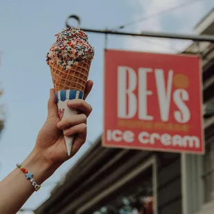 a hand holding an ice cream cone
