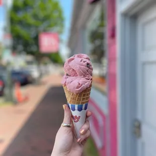 a hand holding an ice cream cone