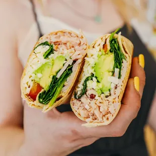 a woman holding a burrito