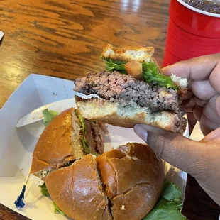 a hand holding a half eaten sandwich