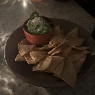 a bowl of guacamole and tortillas