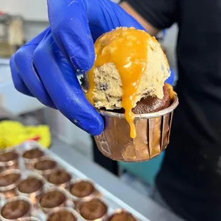 a person holding a cup of ice cream