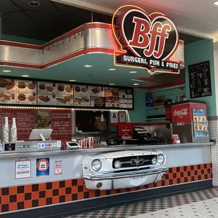 the interior of a diner with a car parked in front of it