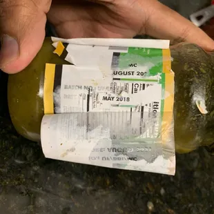 a hand holding a jar of mustard