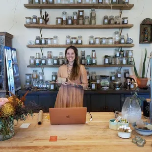 a woman standing in front of a laptop
