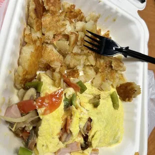 an omelet and a fork in a styrofoam container