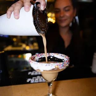 a person pouring a drink