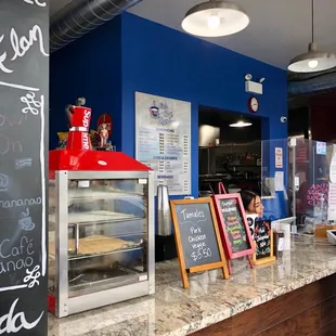 a counter with a chalkboard menu