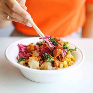 a woman eating a bowl of food