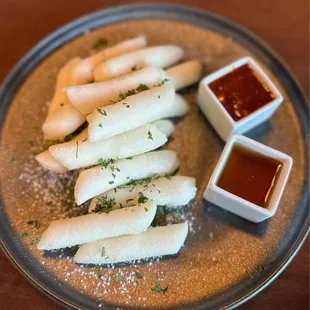 a plate of sushi with dipping sauces