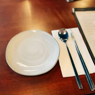 a plate with chopsticks and a spoon
