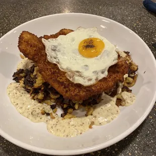 Schnitzel topped with a fried egg, over spatzle and some mystery sauce.