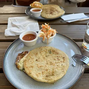 Front: cheese and jalapeño pupusa  Back: carnita pupusa