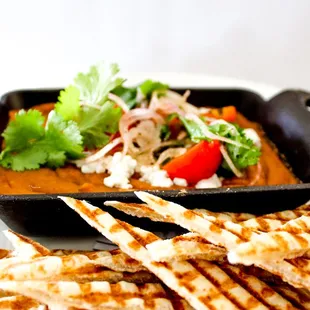 a plate of quesadillas and a bowl of soup