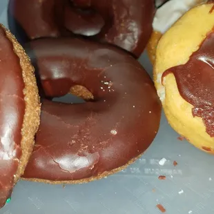 three chocolate donuts on a plate