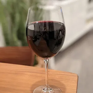 a glass of red wine on a table