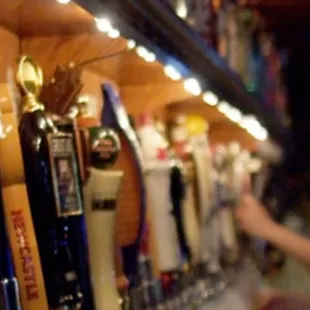 a man standing in front of a row of beer taps