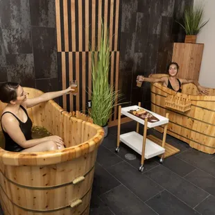two women relaxing in a wooden tub