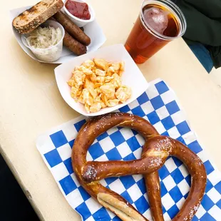 a pretzel, a bowl of chips, and a glass of beer