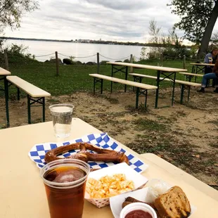 a picnic table with food and a glass of beer