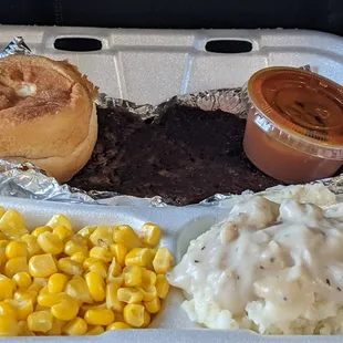 Hamburger with mashed potatoes,corn and roll. BBQ sauce on side