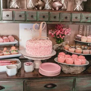 a table with a cake and cupcakes