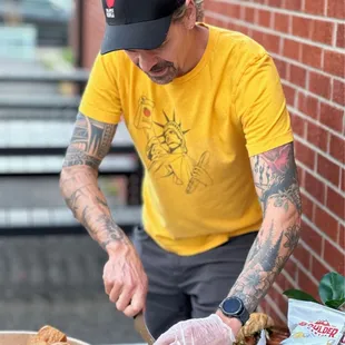 a man cutting a sandwich