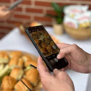 a person taking a picture of a plate of food