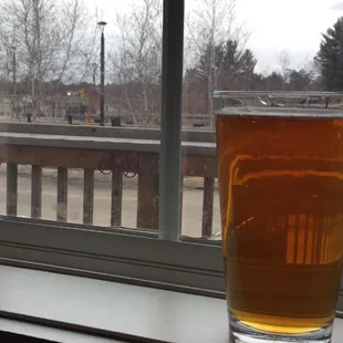a glass of beer on a window sill