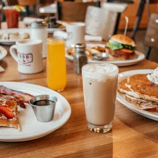 a breakfast of pancakes, bacon, strawberries, and coffee