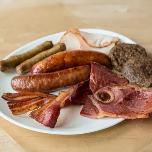 a plate of bacon, sausages, and sausages