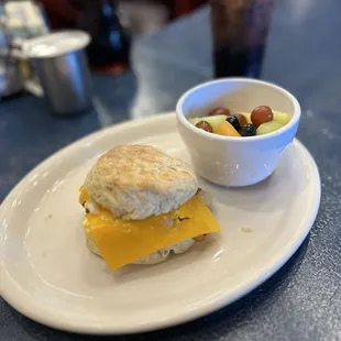 Biscuit with egg, cheese, and bacon with a side of fruit- fantastic