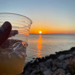 a person holding a glass of orange juice