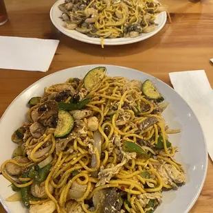 a plate of noodles with mushrooms and zucchini