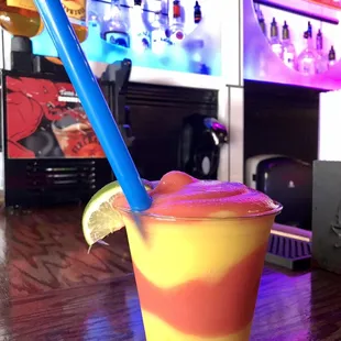 a colorful drink with a blue straw