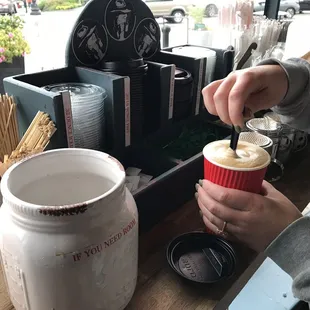 a person pouring coffee into a cup