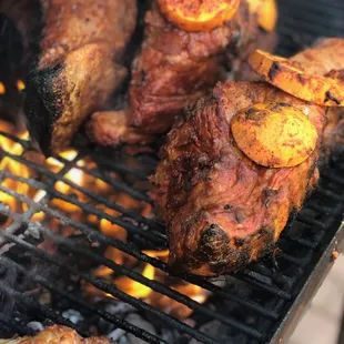 a bbq with meat and vegetables on the grill