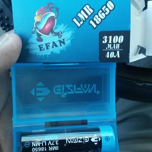 a hand holding a pack of batteries