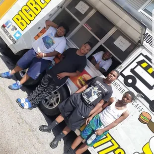 a group of men standing in front of a food truck