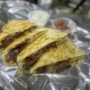 three quesadillas on tin foil