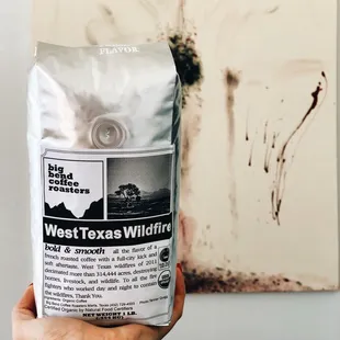 a hand holding a bag of coffee